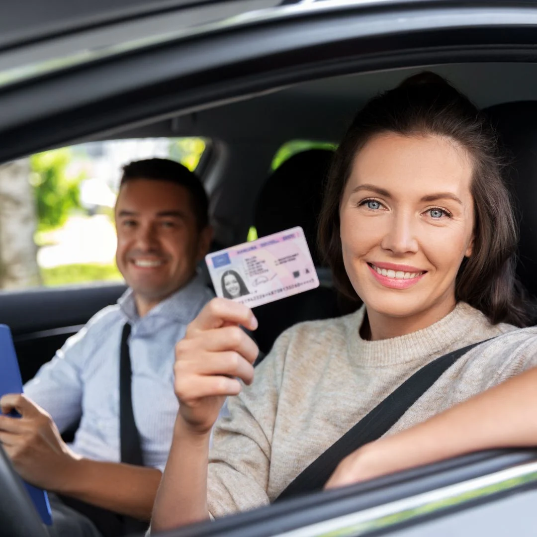 A Girl Showing here driving license sitting in car with his instructors of CDI or Cambridge Driving Instructors